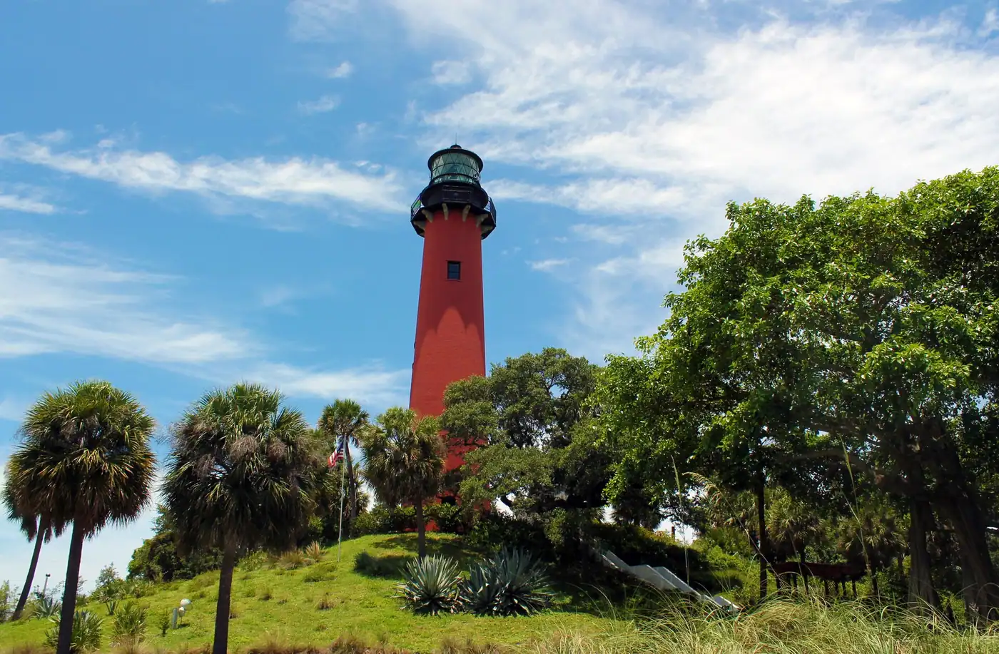 The red Jupiter Inlet Lighthouse above palms and sea grape