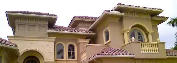 Gutters on a multi level Mediterranean home with a tile roof